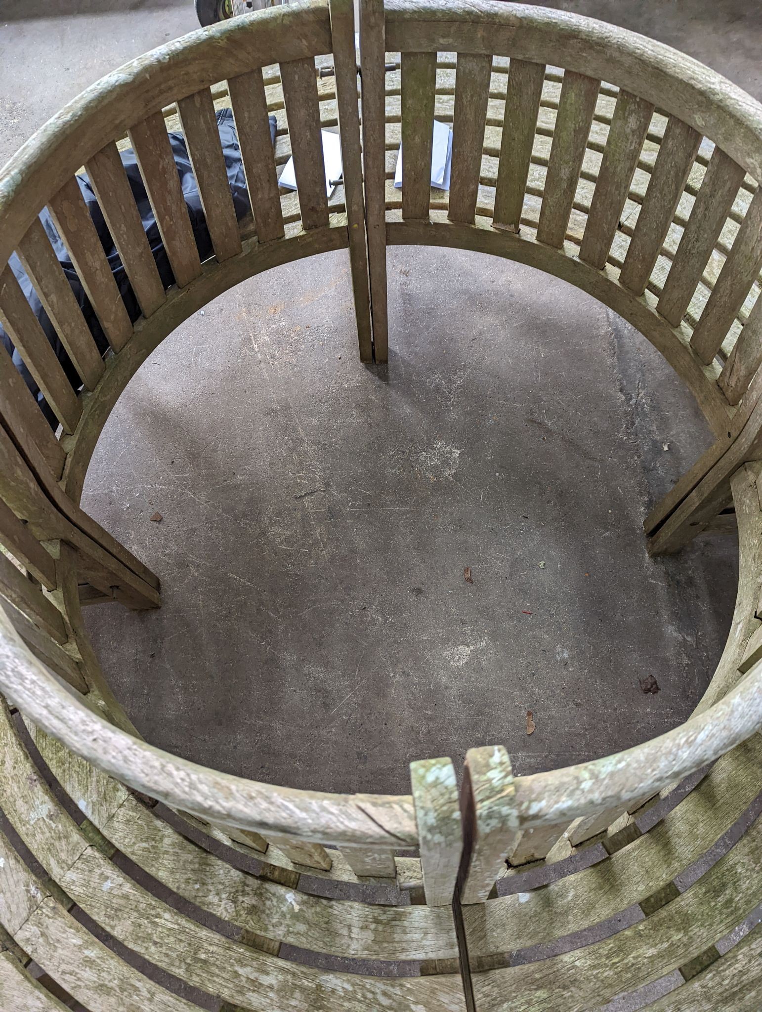 A weathered teak four section tree seat, aperture 90cm diameter, the seat 200cm diameter, height 90cm